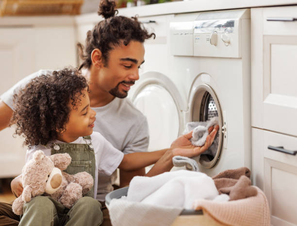 istock Son helping dad to load washing machine 1398820420