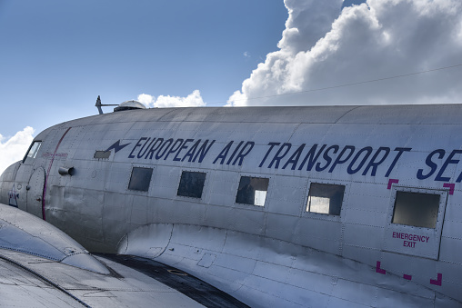 Lakeland, Florida, April 2022 - Vintage DC 3 European Air Transport plane photographed as it is fying through clouds in the air