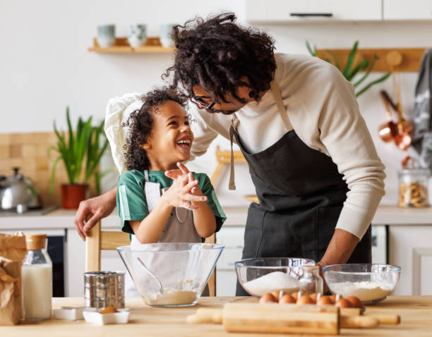 istock Happy black father and son preparing dough together 1398821670