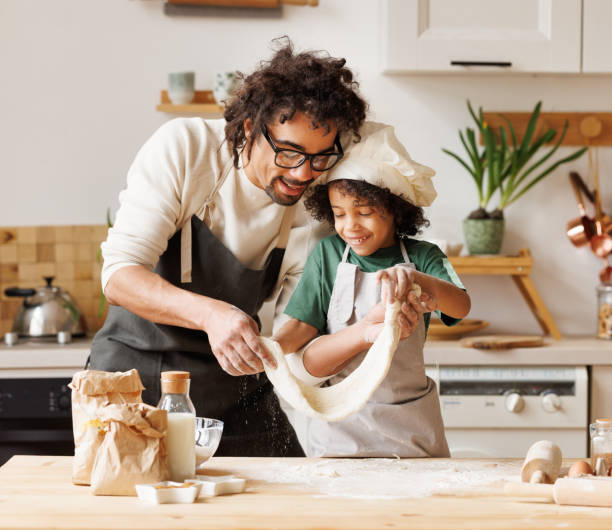 istock Happy black father and son preparing dough together 1398821954