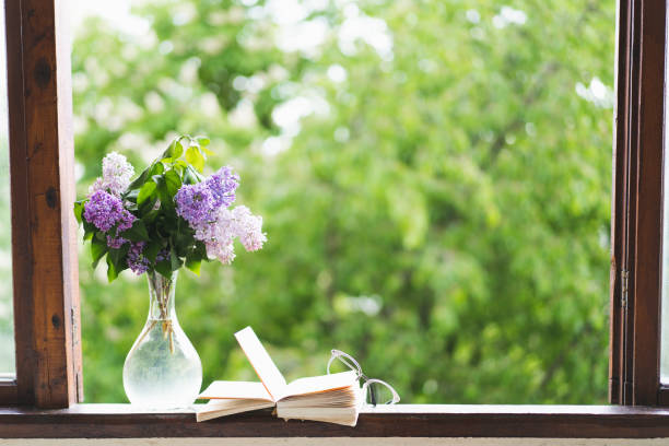istock Book, glasses and lilac on a wooden window 1398823551