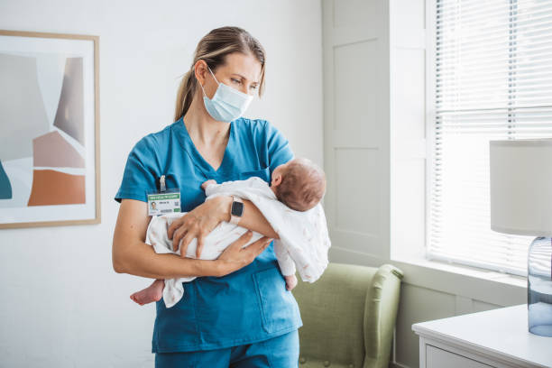 pielęgniarka pediatra opiekująca się noworodkiem na oddziale szpitalnym. - male nurse nurse hospital ward hospital zdjęcia i obrazy z banku zdjęć