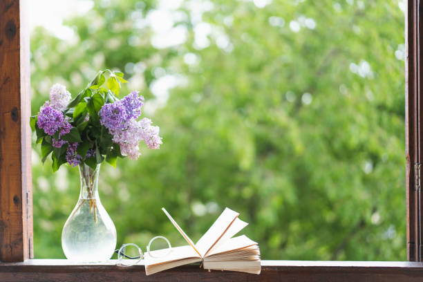 istock Book, glasses and lilac on a wooden window 1398823562