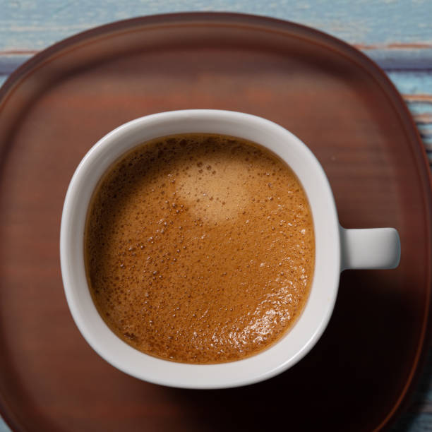 istock Brown espresso coffee served on a white cup on a brown plate close up still 1398823912