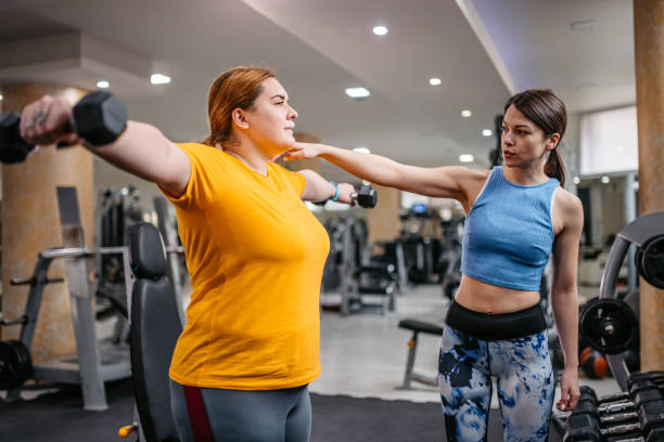 istock Young Overweight Woman Exercising With Her Instructor 1398825388