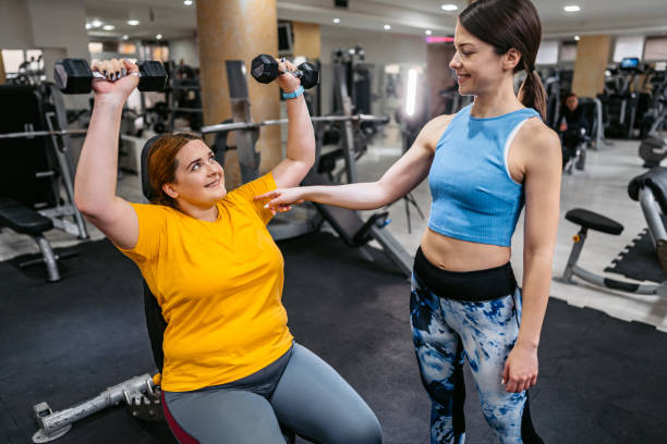 istock Young Overweight Woman Exercising With Her Instructor 1398826245