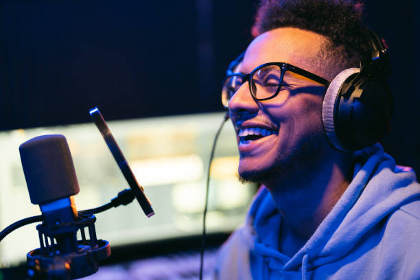 istock Young male singer in recording studio performing in neon lights 1398826400