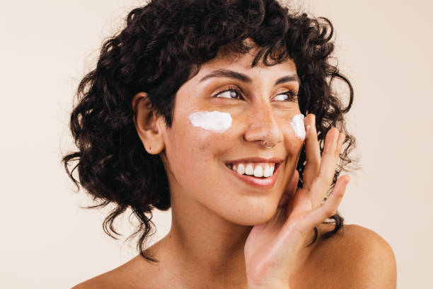 istock Woman applying cosmetic moisturizer on her face 1398828236