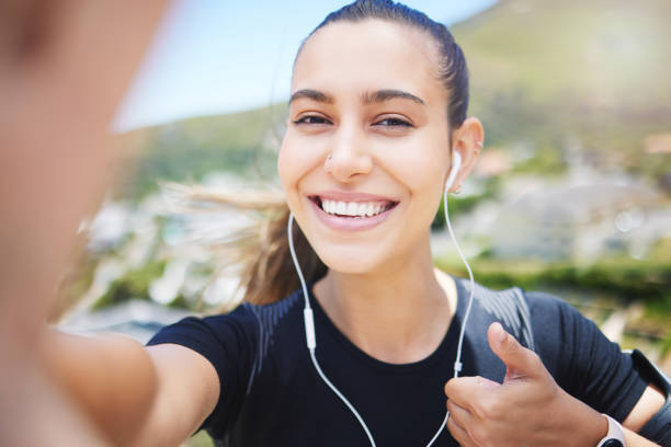 istock A fit young mixed race female jogger showing a thumbs up gesture outside while taking a selfie after a good exercise outdoors 1398828241