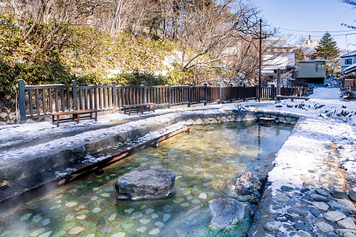Relaxing in Traditional japanese rotenburo outdoor onsen bath and winter scenery with snow and thermal steam, Iturup hot springs on Kuril islands