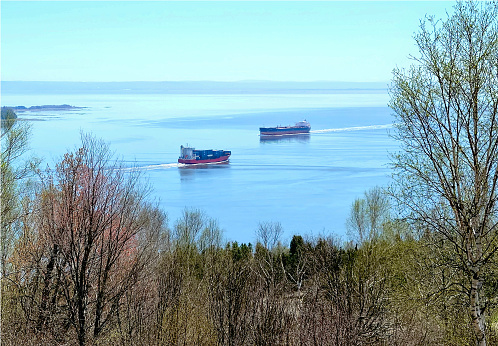 Lifestyle...From high up, we see two freighters passing one another on the St. Lawrence River, in  the province of Quebec, Canada. This image is taken near Baie St. Paul, down river, from Quebec City.