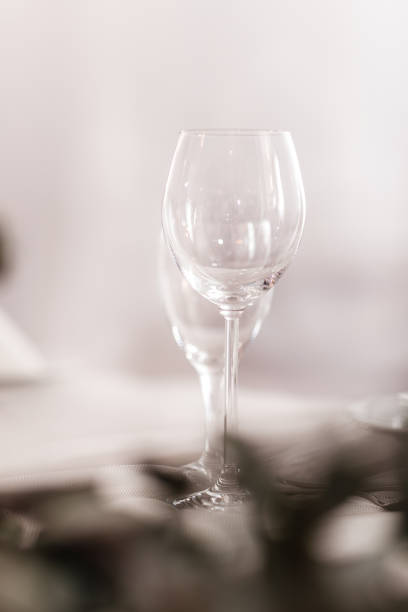 istock Empty glass set in restaurant. wedding, decor, celebration, holiday concept - romantic table setting with white tablecloth, plates, crystal glasses 1398829953