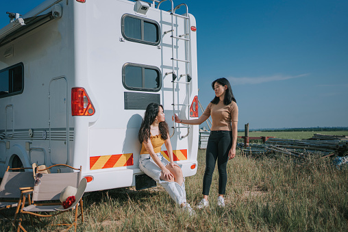 Asian Chinese Lesbian couple enjoying campervan outdoor road trip during weekend morning