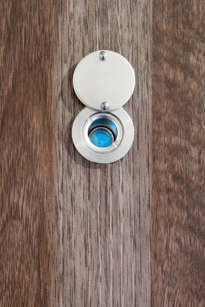 Eye peephole in dark brown wooden door