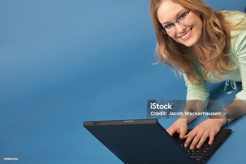 Mujer joven feliz trabajando en un ordenador portátil - Foto de stock de 20 a 29 años libre de derechos