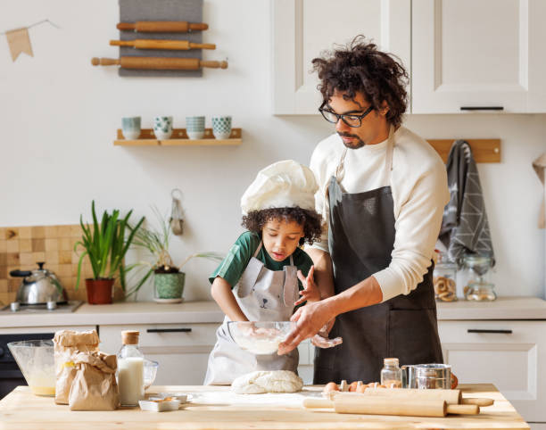 istock Happy black father and son preparing dough together 1398834285