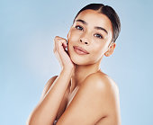 istock Closeup face beautiful young mixed race woman. An attractive female posing in studio isolated against a blue background. A skincare regime that keeps your skin soft, smooth, glowing and healthy 1398835034