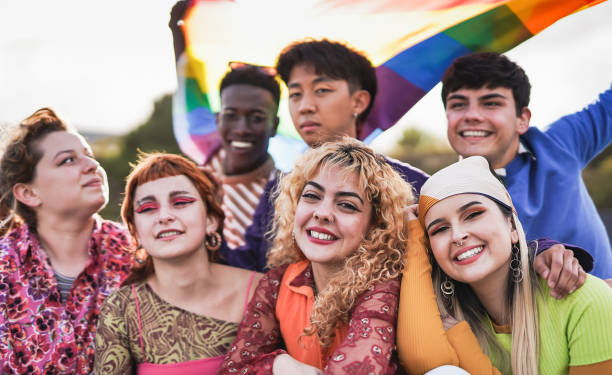 istock Young diverse people having fun at LGBT pride parade holding rainbow flag 1398836199