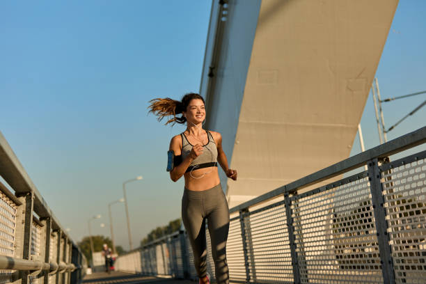 istock Female jogger running over the bridge 1398836743