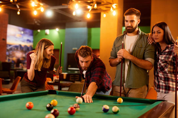 istock Group of friends having fun while playing pool in a local pool hall 1398837047