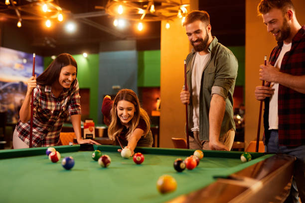 istock Group of friends having fun while playing pool in a local pool hall 1398838426