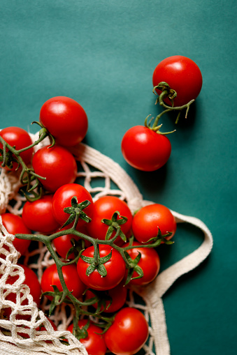 Fresh cherry tomatoes in the dish on a wooden board.