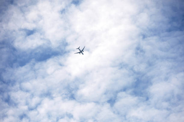 istock Airplane flying in the blue sky covered with white clouds 1398840237