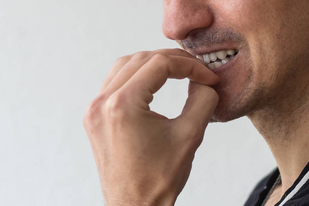 istock Frightened man feeling scared and biting his nails on a light background. 1398841212