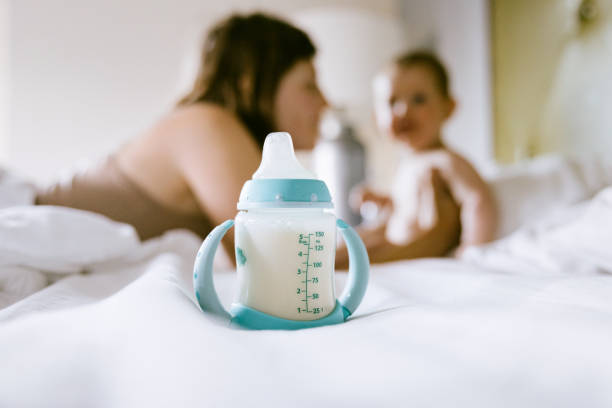 biberon per latte in primo piano di madre e bambino - scarcity foto e immagini stock