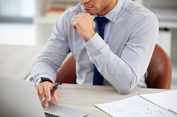 istock Mixed race businessman working on a laptop reading an email alone in an office at work. One hispanic typing an email on a laptop while sitting at a desk at work 1398844427