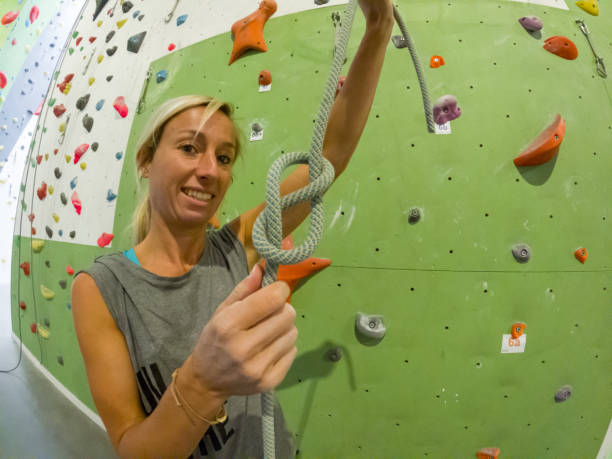 istock Woman tying a knot in preparation for indoor climbing 1398845430