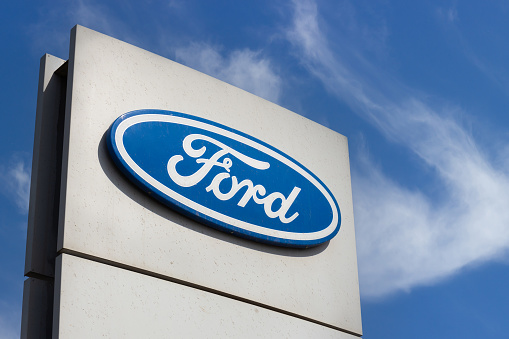 Krasnoyarsk, Russia - May 19, 2022: Close-up Ford brand logo on against blue sky background. Dealership centre of car shop