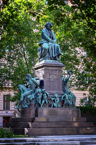 Beethoven monument on the Beethovenplatz square with lots of trees in Vienna, Austria.