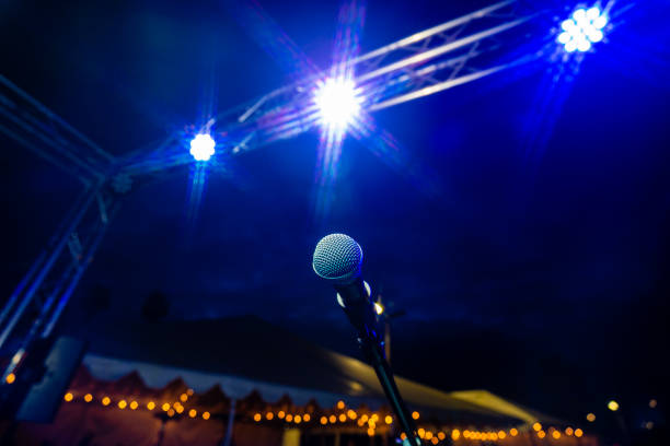 comedia o espectáculo de música en vivo por la noche al aire libre con micrófono y luces azules vida nocturna - concierto de música pop fotografías e imágenes de stock