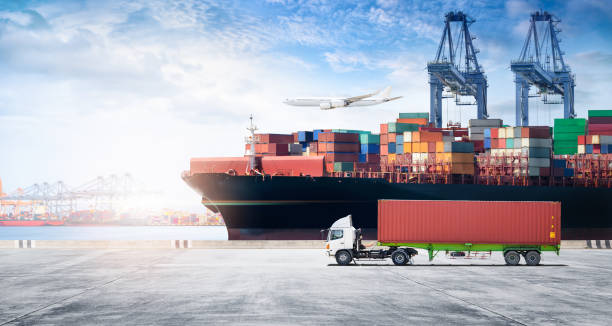 Container cargo freight ship during discharging at industrial port move to container yard by trucks, handlers, cargo plane, copy space, logistic import export background and transport industry concept stock photo