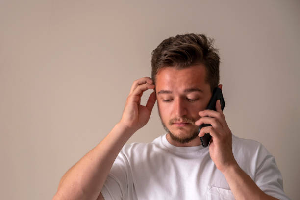 istock handsome young man scratching his hair with his hand while talking on the phone 1398849817