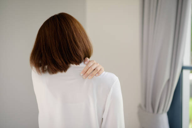 Rear view of an Asian woman with shoulder pain symptoms. stock photo