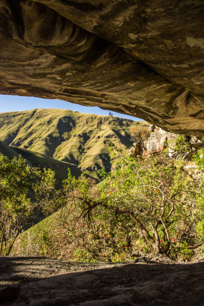 Looking out at the grass covered slopes of the Drakensberg Mountains, from Marble Baths Cave. stock photo