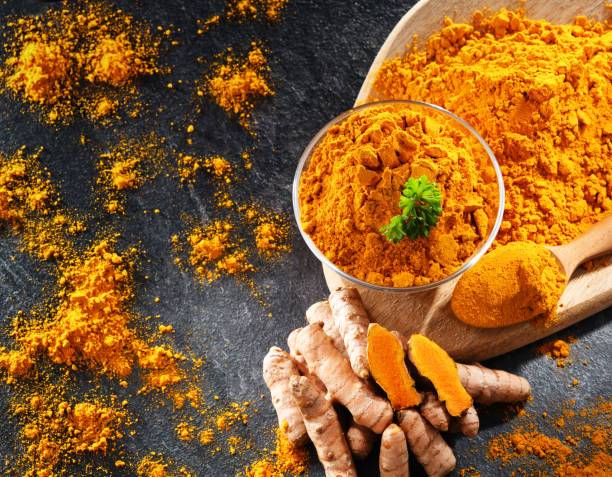 istock Composition with a bowl of ground turmeric and its fresh rhizome 1398851396