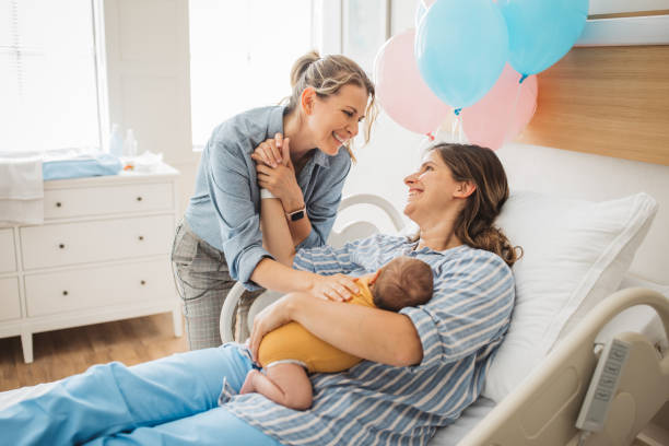 生まれたばかりの赤ちゃんを持つ女性のゲイカップル - maternity clinic ストックフォトと画像