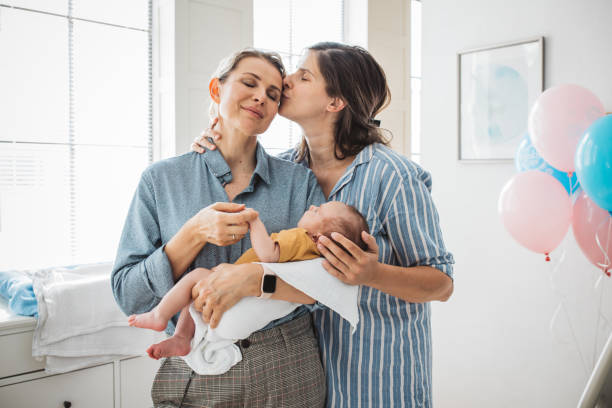 Female gay couple with newborn baby stock photo