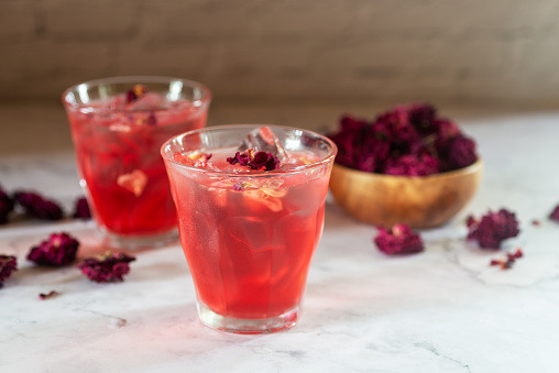 glass of rose Kombucha with iced on white table ,fermented tea drink, healthy beverage.