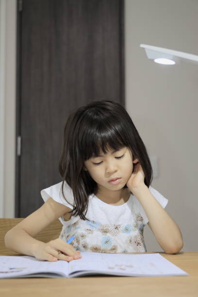 istock studying Japanese girl in dining room (7 years old) 1398853369