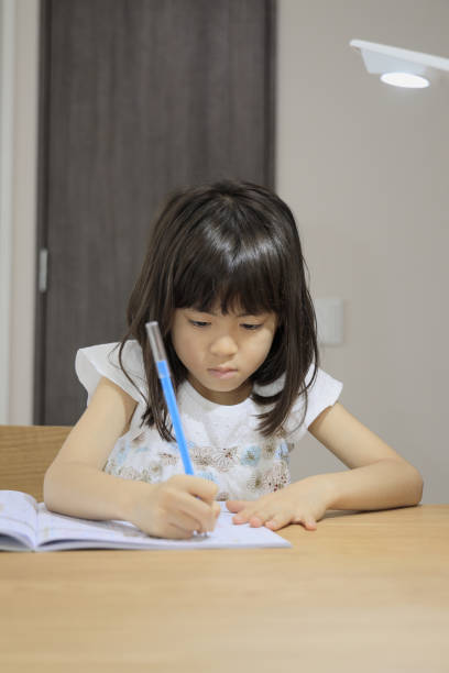 istock studying Japanese girl in dining room (7 years old) 1398853385