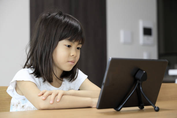 istock studying Japanese girl in dining room (7 years old) 1398853513