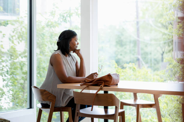 istock While waiting for friend, woman looks out window 1398854662