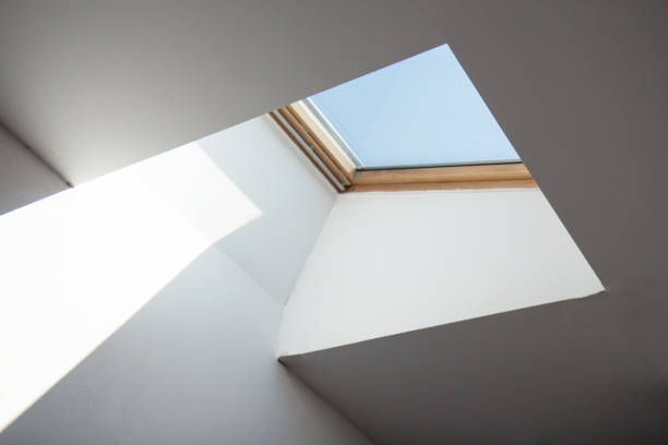 Square ceiling window. Looking up to the sky Dormer wooden window in the white sloping ceiling. Square ceiling window. Looking up to the blue sky skylight stock pictures, royalty-free photos & images