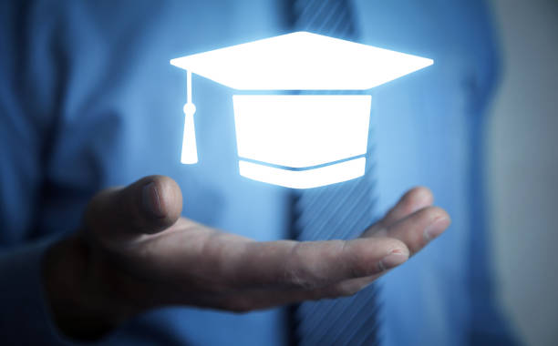 istock Man holding graduation cap symbol. Education 1398856142