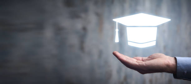 istock Man holding graduation cap symbol. Education 1398856326