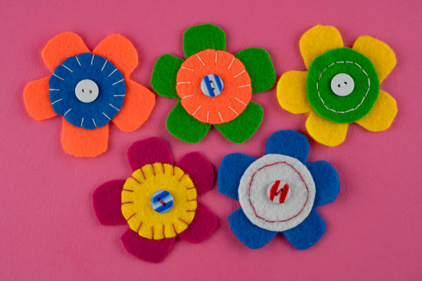 istock Handmade colorful flowers with buttons on pink background 1398856947